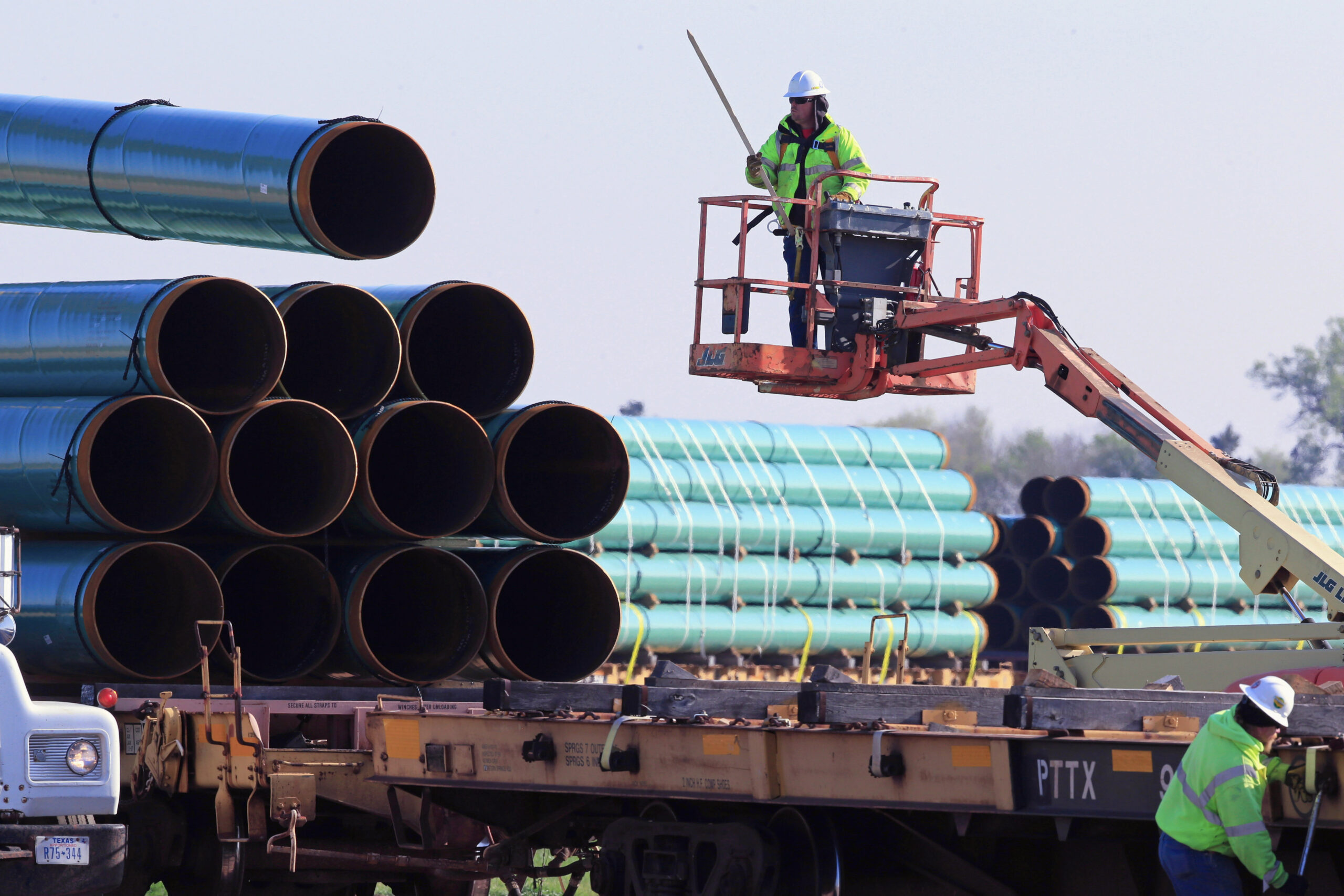 Pipeline Oversight Fees FILE - In this May 9, 2015 file photo, workers unload pipes at a staging area in Worthing, S.D., for the proposed 1,130-mile Dakota Access Pipeline that would stretch from the Bakken oil fields in North Dakota through South Dakota and Iowa to a hub in Illinois. North Dakota is assessing an additional fee to cover the cost of a contractor to monitor construction of the pipeline. The North Dakota Public Service Commission approved the permit for the Dakota Access Pipeline in January 2016. (AP Photo/Nati Harnik, File)